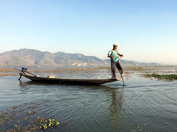 Pêcheur qui rame avec une jambe sur le lac Inle  . . .